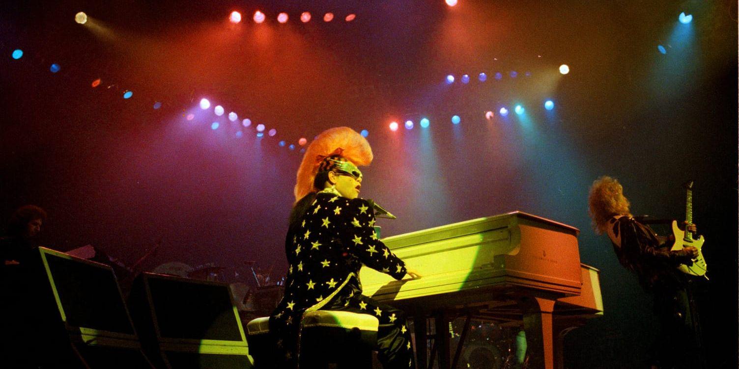 Elton John uppträder iförd en stjärnprydd frack och rosa tuppkam på Universal Amphitheater i Kalifornien 1986. Arkivbild.