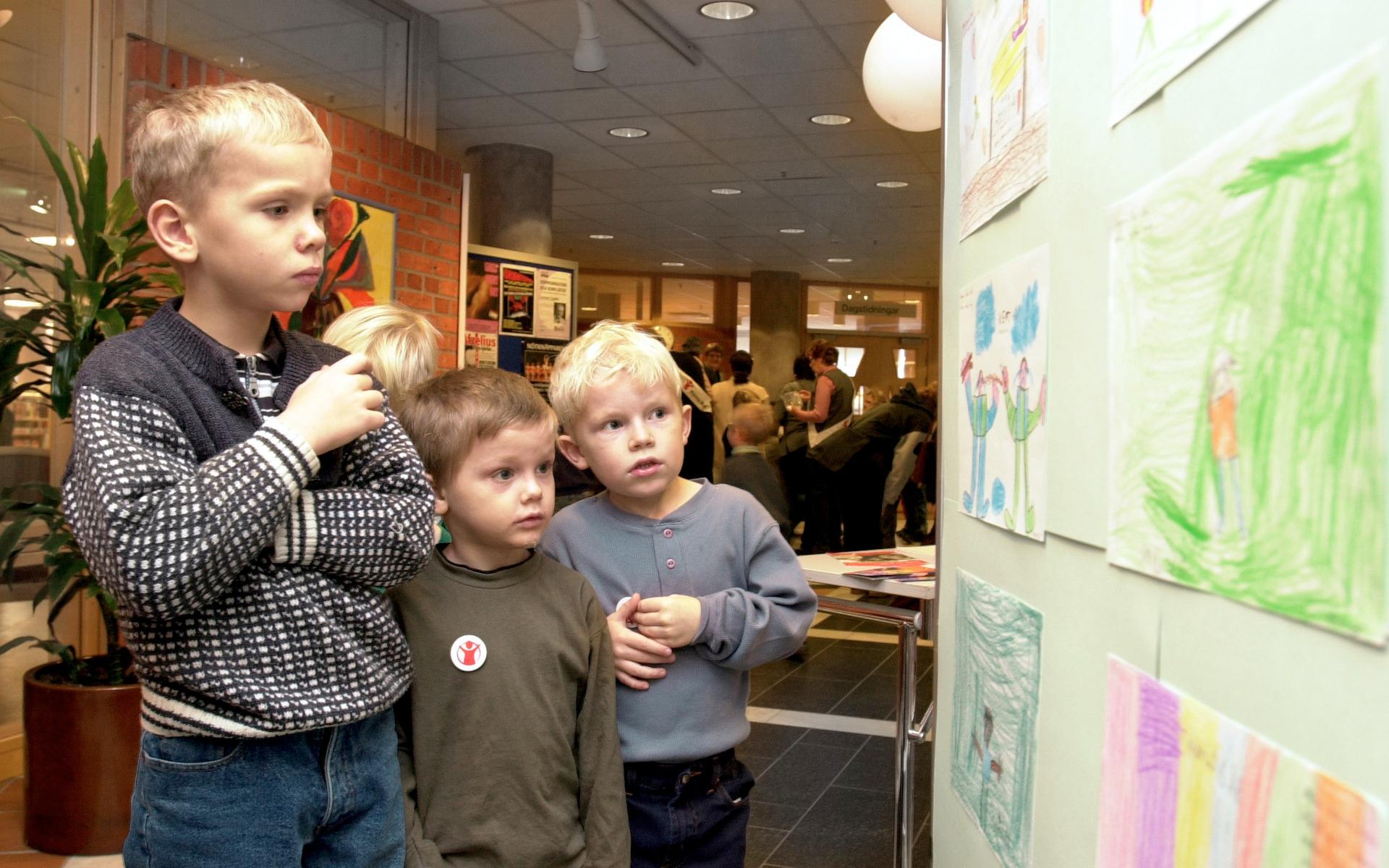 Teckningsutställning i Folkets hus i Rädda Barnens regi. Här tittar från vänster: Jonathan Tengberg, Albin Berggren och Kevin Segedahl från Simsnäppans förskoleklass på några av bidragen.