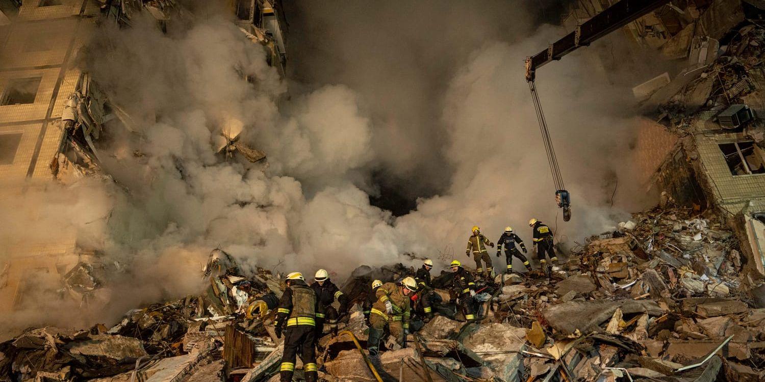  Emergency workers clear the rubble after a Russian rocket hit a multistory building leaving many people under debris in the southeastern city of Dnipro, Ukraine, Saturday, Jan. 14, 2023. (AP Photo/Evgeniy Maloletka)  MAL103